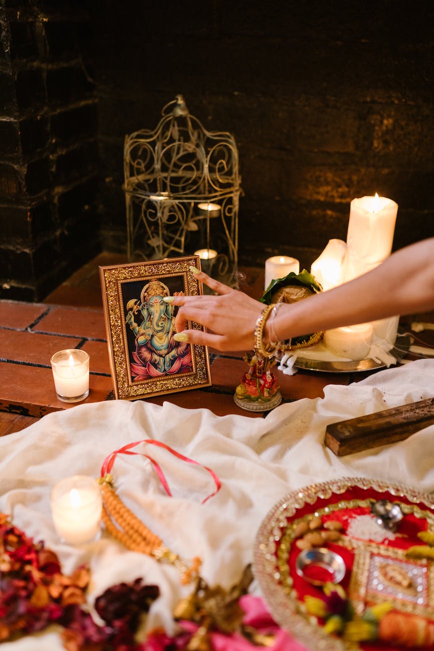 a frame of ganesha beside lighted candles