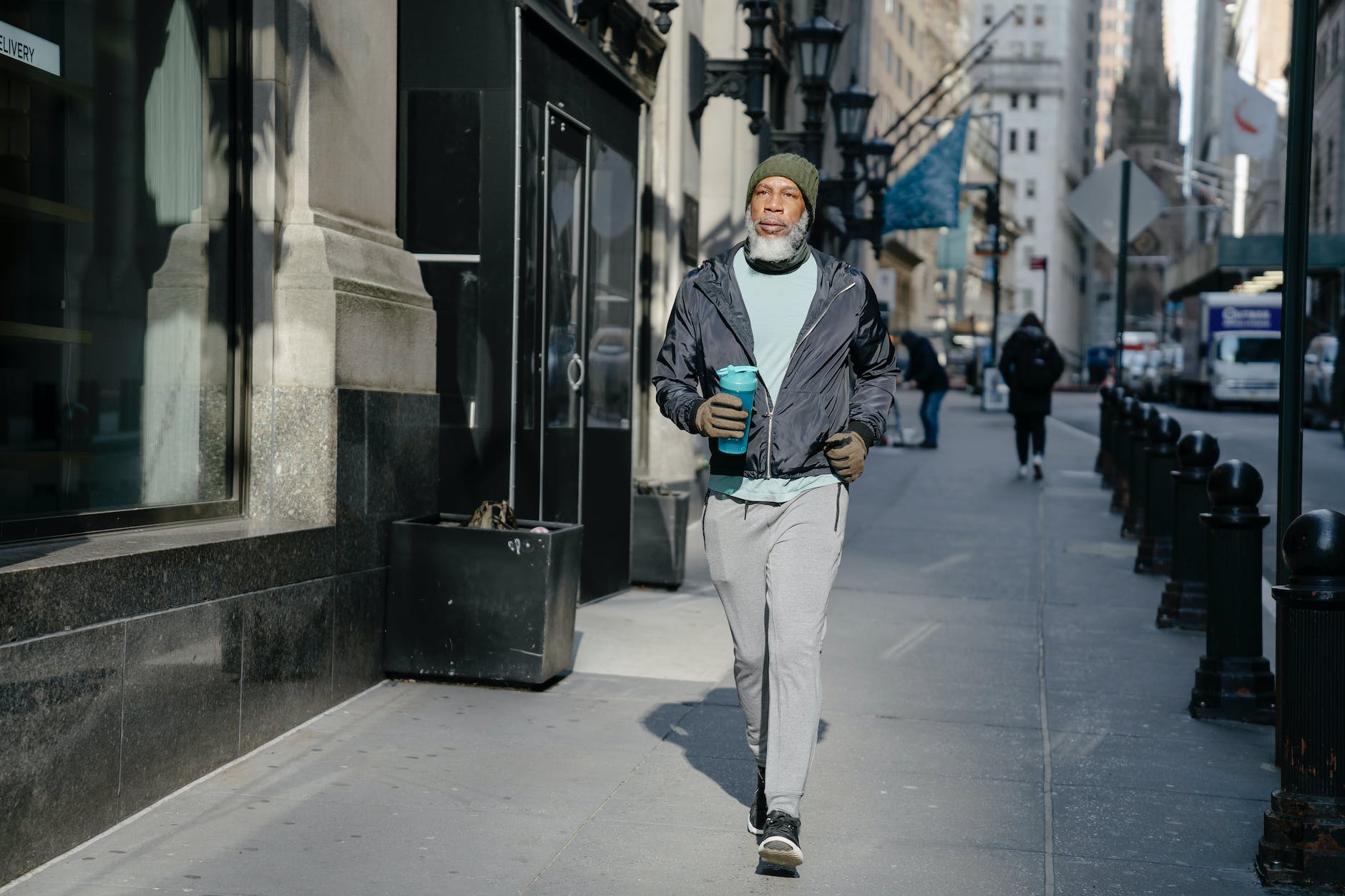 senior black man walking on pavement in city
